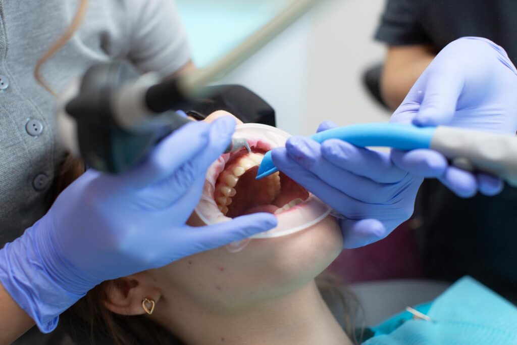 airflow teeth cleaning of a young patient at a dental clinic
