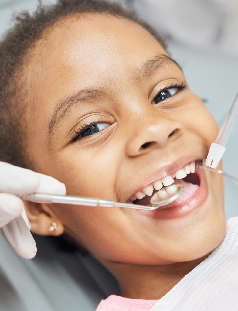 An african child smiling during her dental treatment
