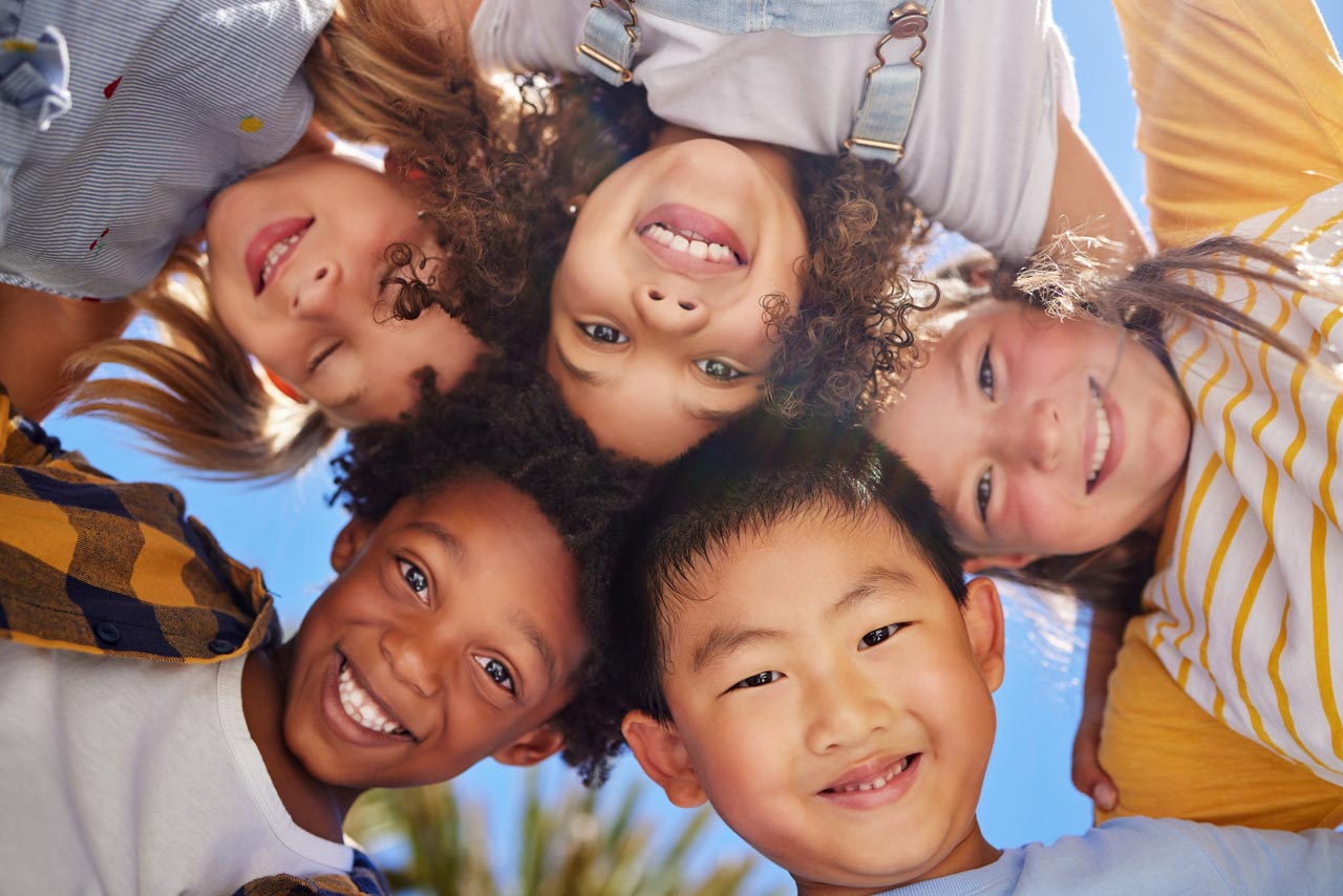 A group of children from different background smiling at the camera