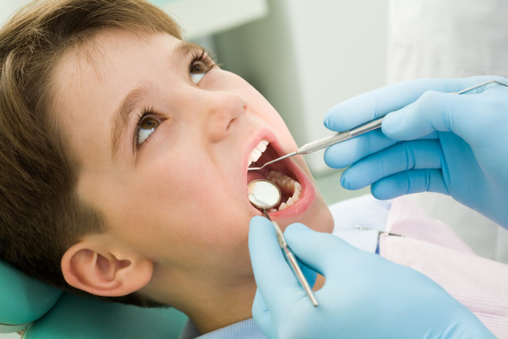 dentist examining a child teeth, preventive treatment